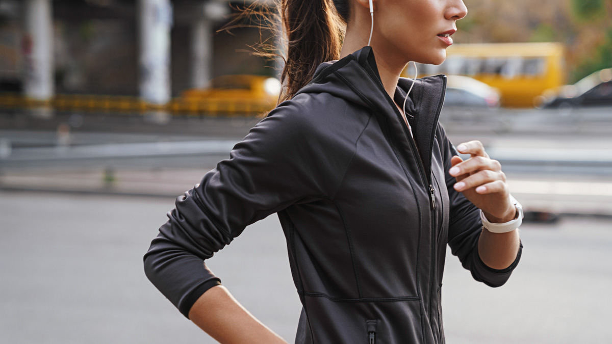 Woman Completing A Run Streak As Her Winter Training Challenge Image Of A Young Gorgeous Strong Sports Woman Running Outdoors By Street Listening Music.