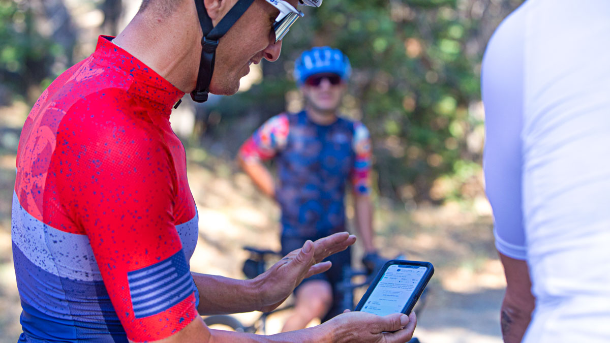 Cyclist Looks At His Aerobic Fitness And Vo2 Max Progression Using The Trainingpeaks App Male Cyclist In Red Jersey Looks At The Trainingpeaks App On His Phone After A Fitness Test