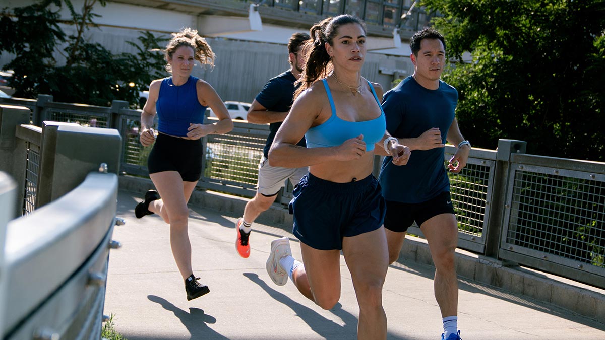 Group Of Runners Running On Bridge