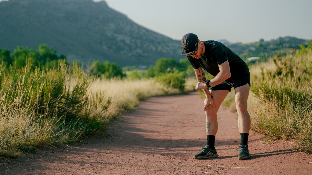 Runner Man On Dirt Road Outside Checking Watch To Adjust Running In The Heat